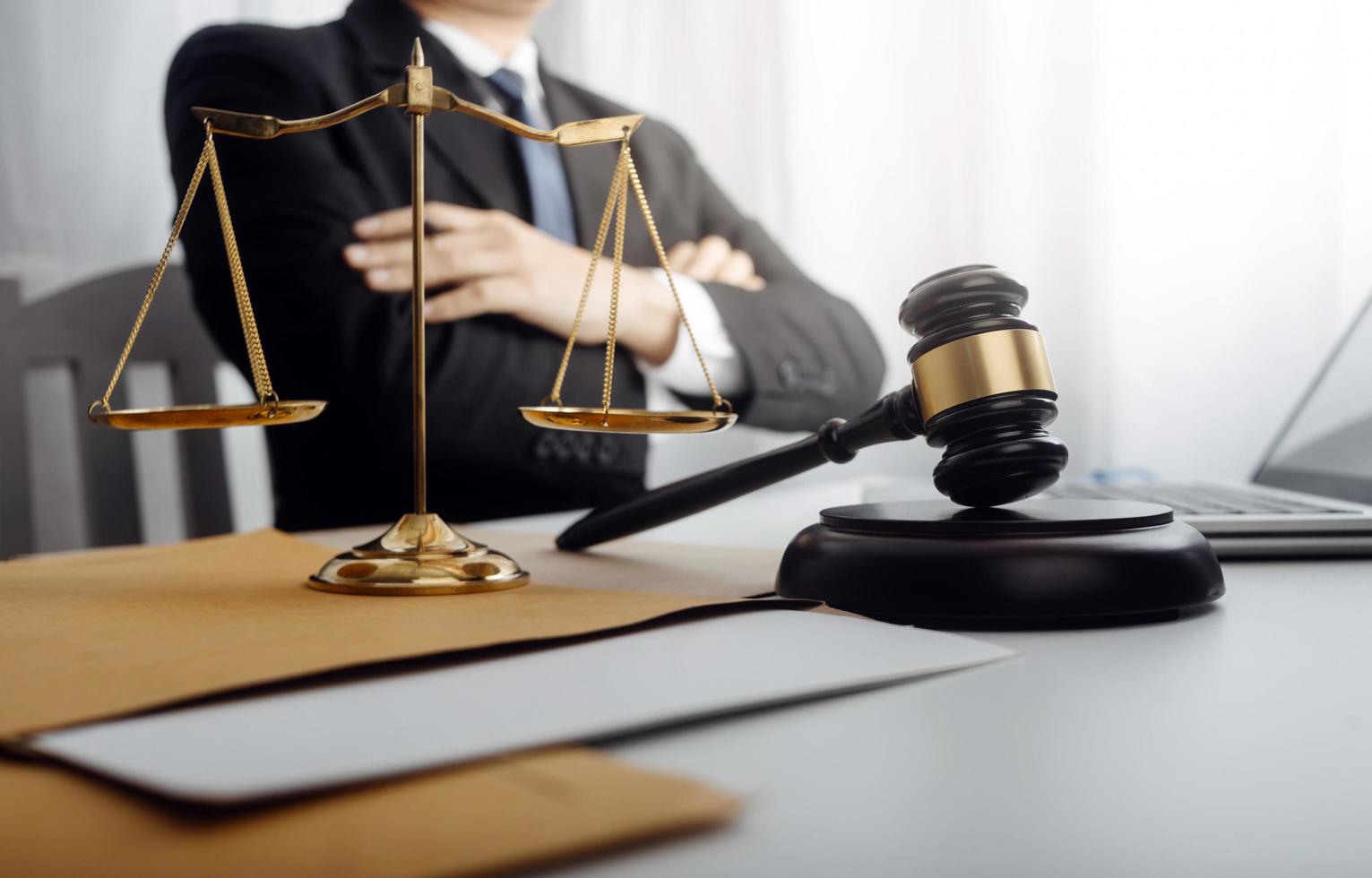 Justice and law concept.Male judge in a courtroom with the gavel, working with, computer and docking keyboard, eyeglasses, on table in morning light photo