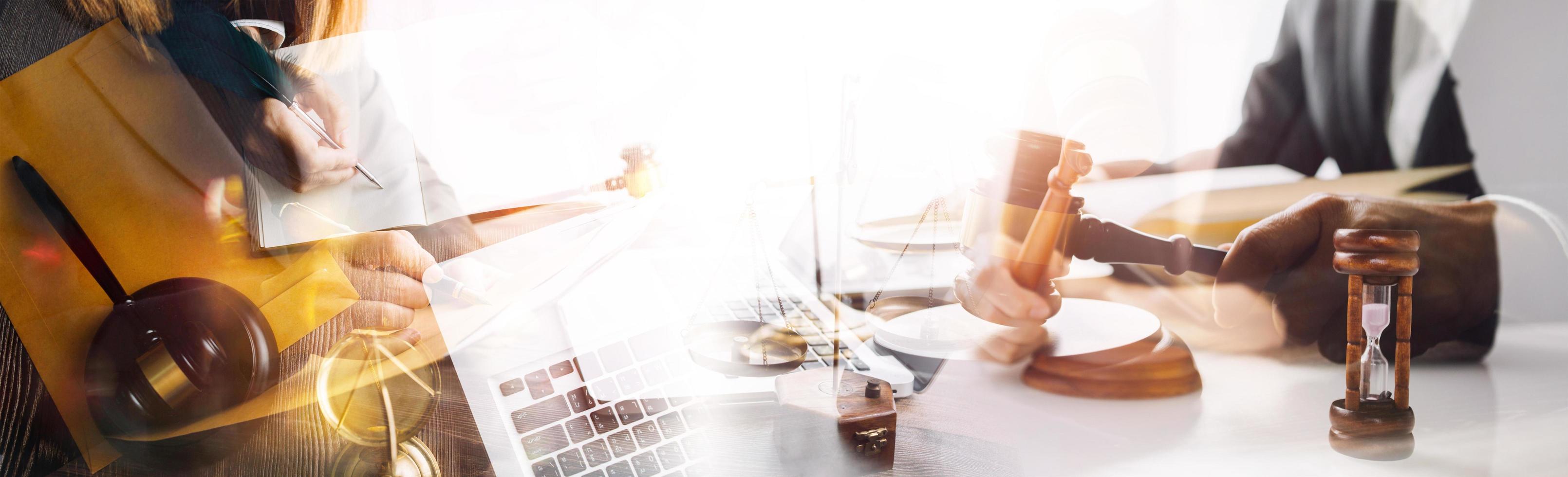 Justice and law concept.Male judge in a courtroom with the gavel, working with, computer and docking keyboard, eyeglasses, on table in morning light photo