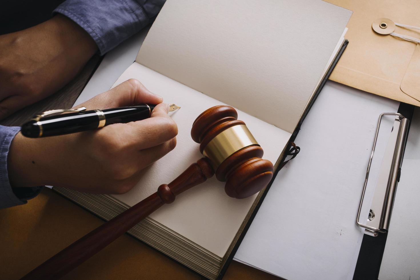 Male lawyer working with contract papers and wooden gavel on tabel in courtroom. justice and law ,attorney, court judge, concept. photo