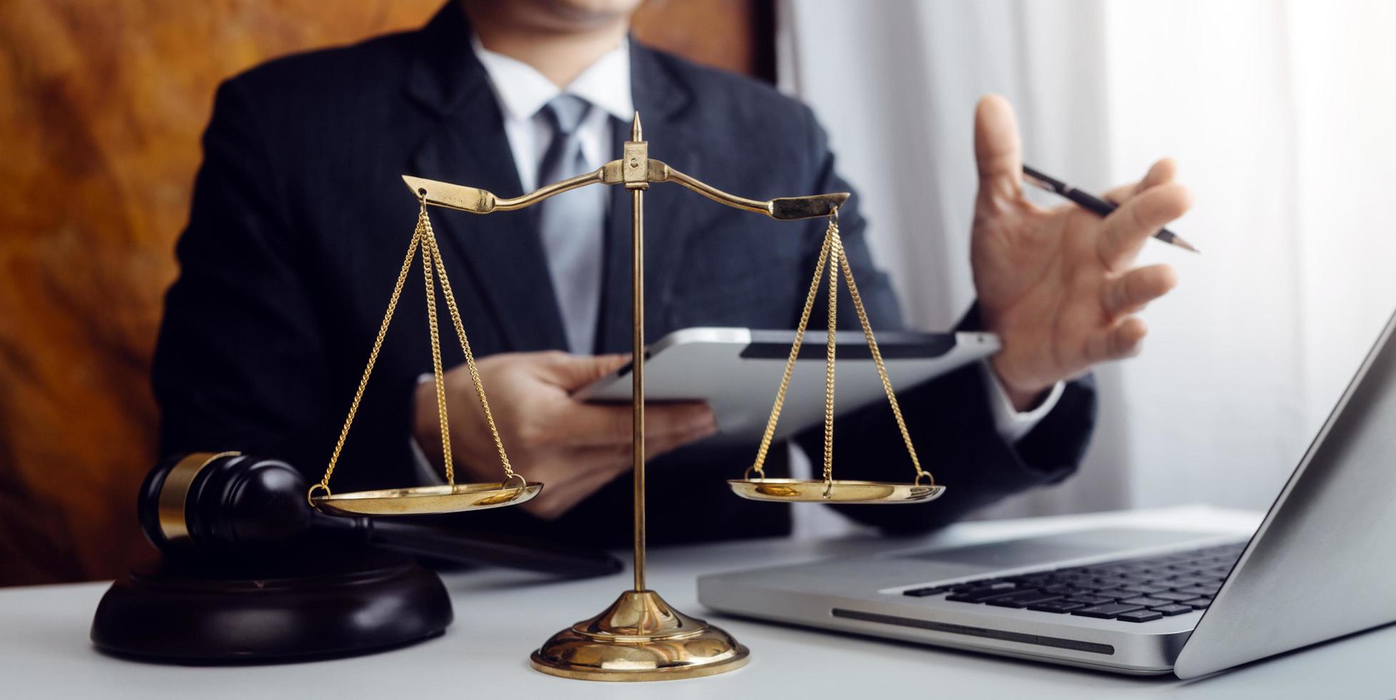 Business and lawyers discussing contract papers with brass scale on desk in office. Law, legal services, advice, justice and law concept picture with film grain effect photo