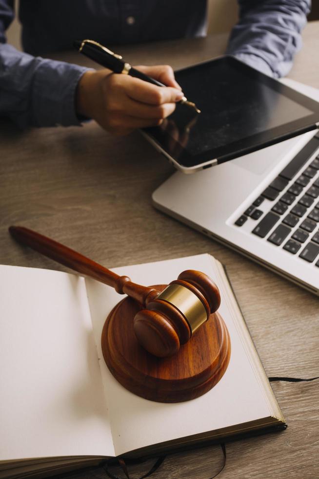 Male lawyer working with contract papers and wooden gavel on tabel in courtroom. justice and law ,attorney, court judge, concept. photo