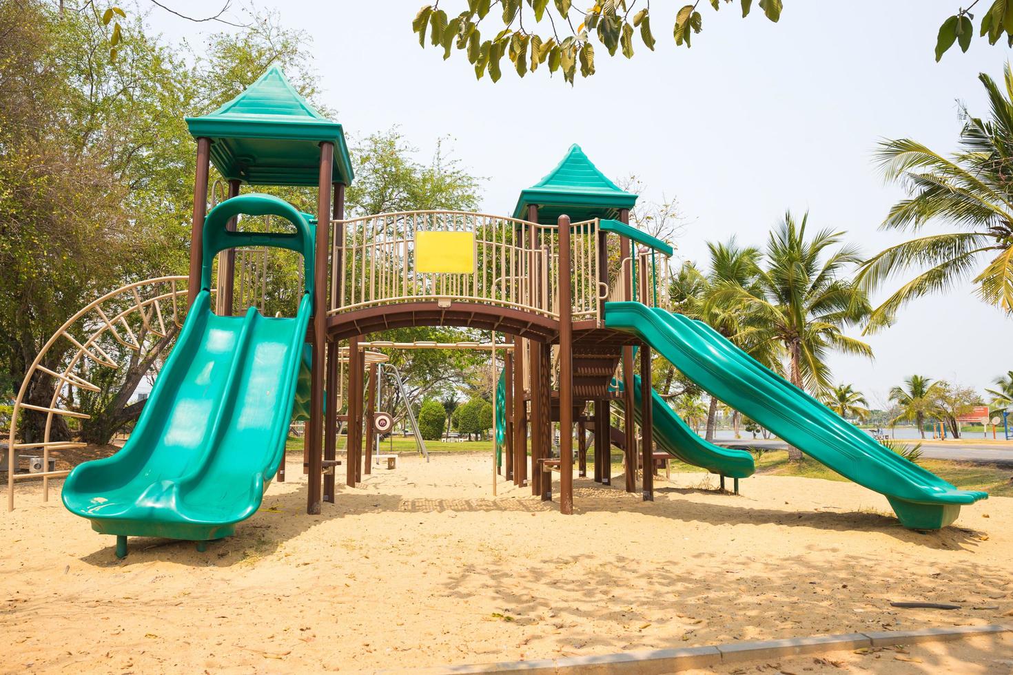 Green playground on yard in the park with tree photo