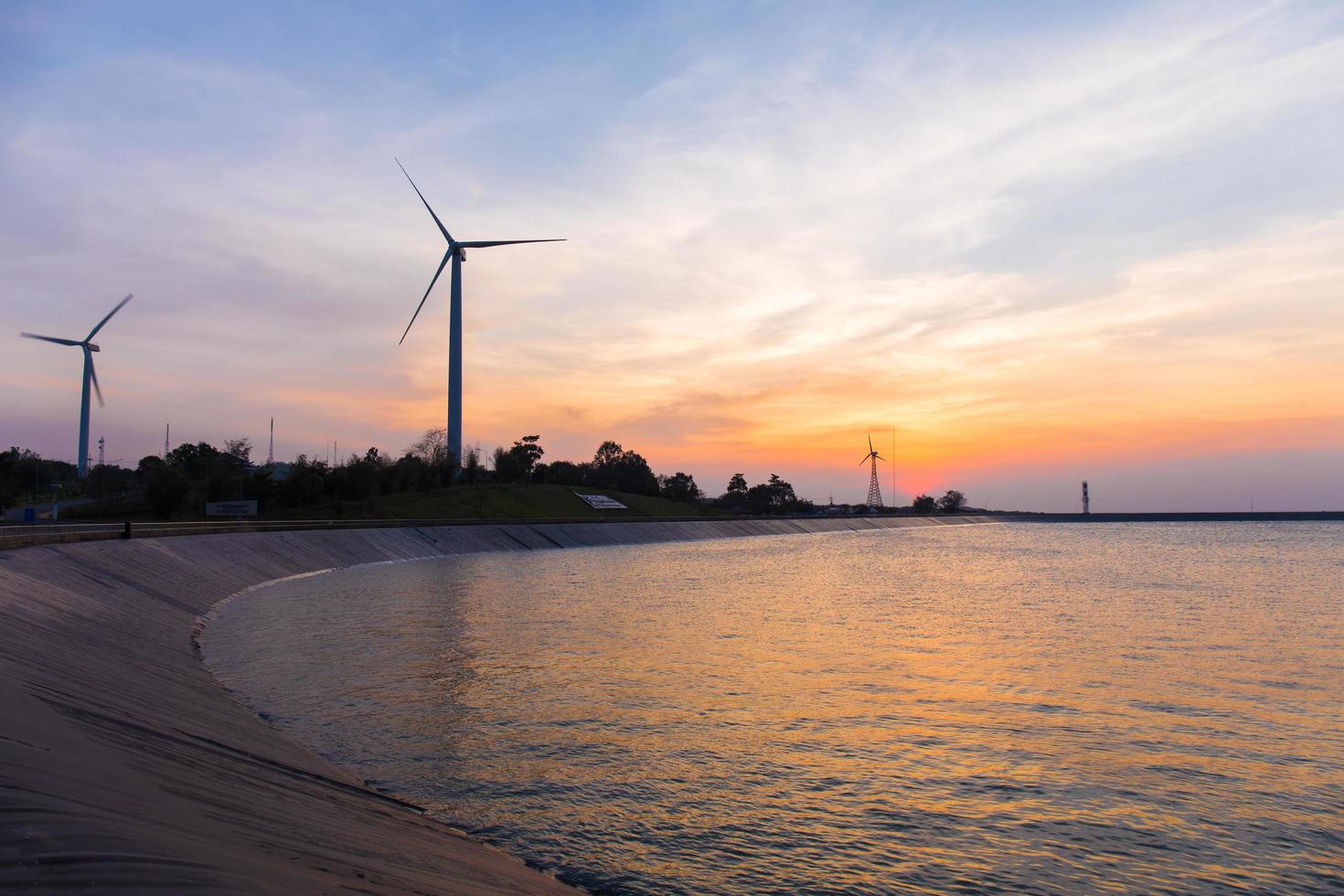 power generator wind turbines at twilight time with reservoir photo