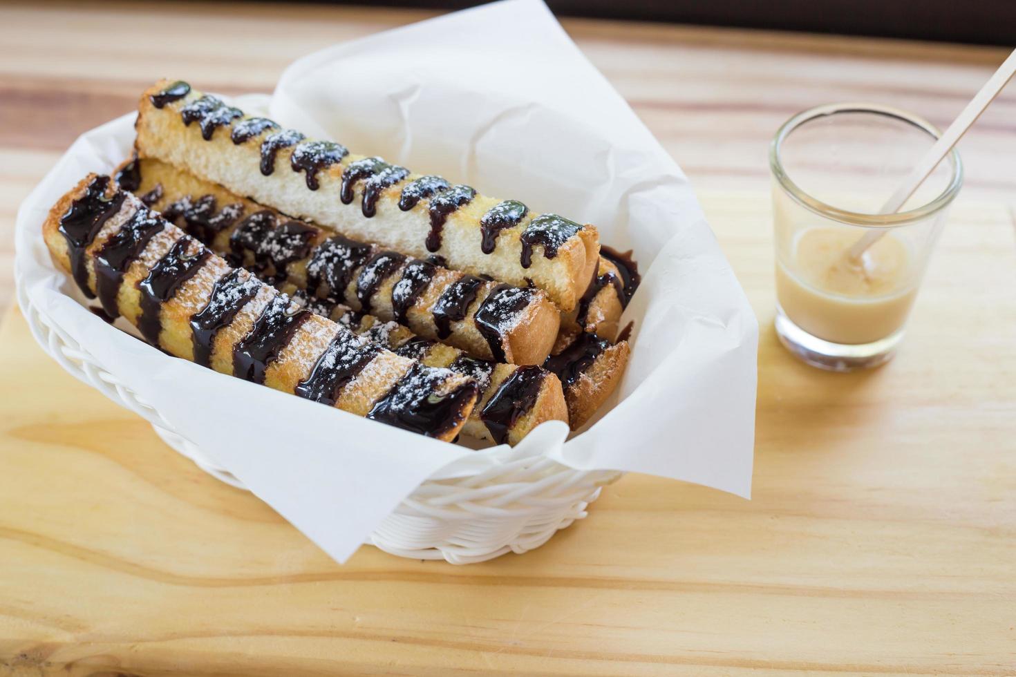 Fresh Croissant or Bread with chocolate topping on wooden table photo