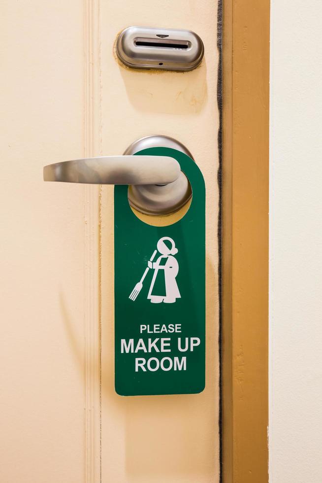 Please make up room sign on door knob in hotel closeup photo