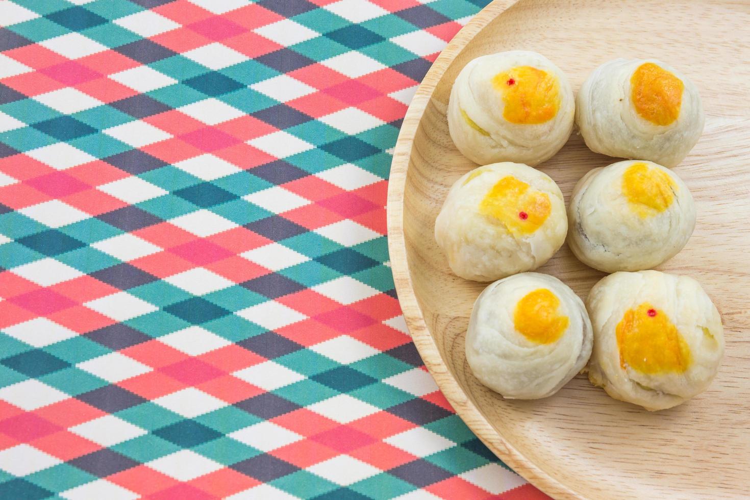 Chinese Pastry Mung Bean or Mooncake with Egg Yolk on wooden dish striped cloth photo