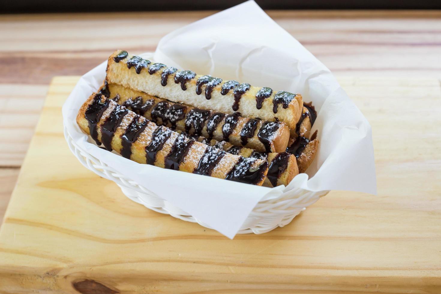 Fresh Croissant or Bread with chocolate topping on wooden table photo