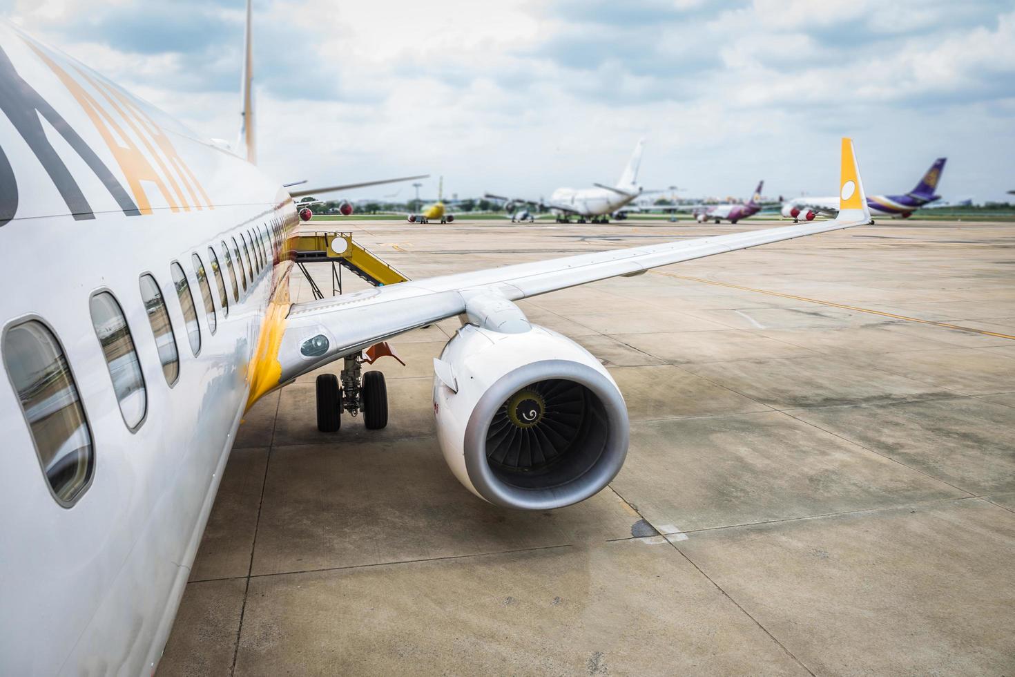 Wing of airplane turbine detail on airport in field standby or wait passenger. View from the top photo