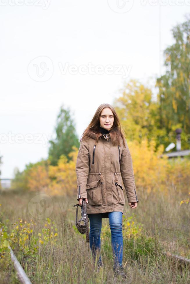 Portrait of young cute woman in fall autumn park. Beautiful caucasian girl walking in forest photo
