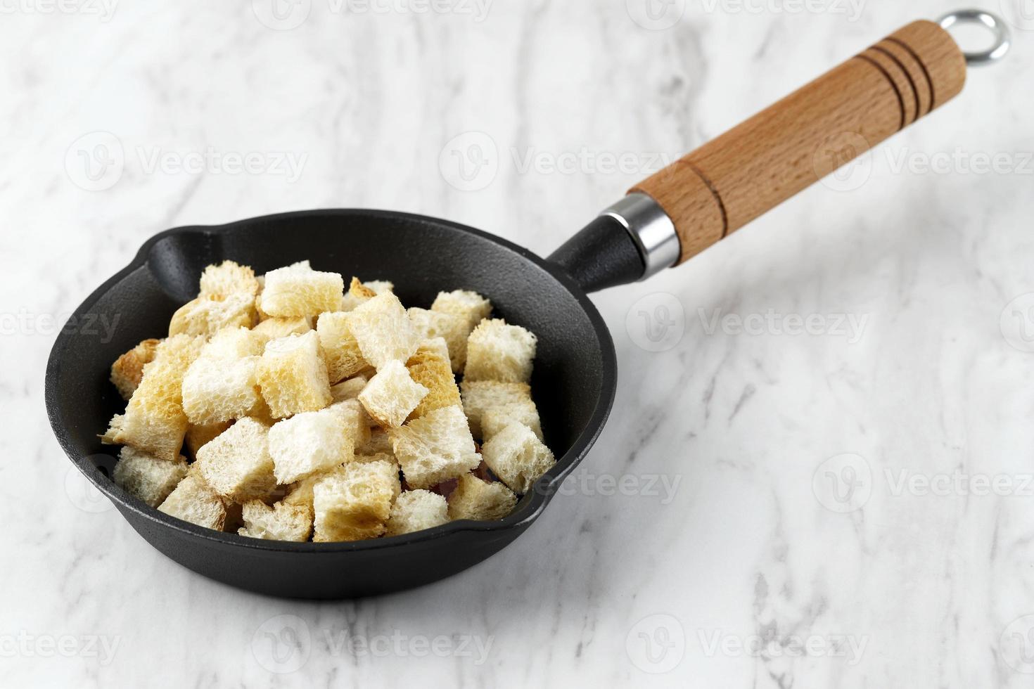 crutones caseros crujientes para guarnición de sopa, servidos en una sartén de hierro fundido foto