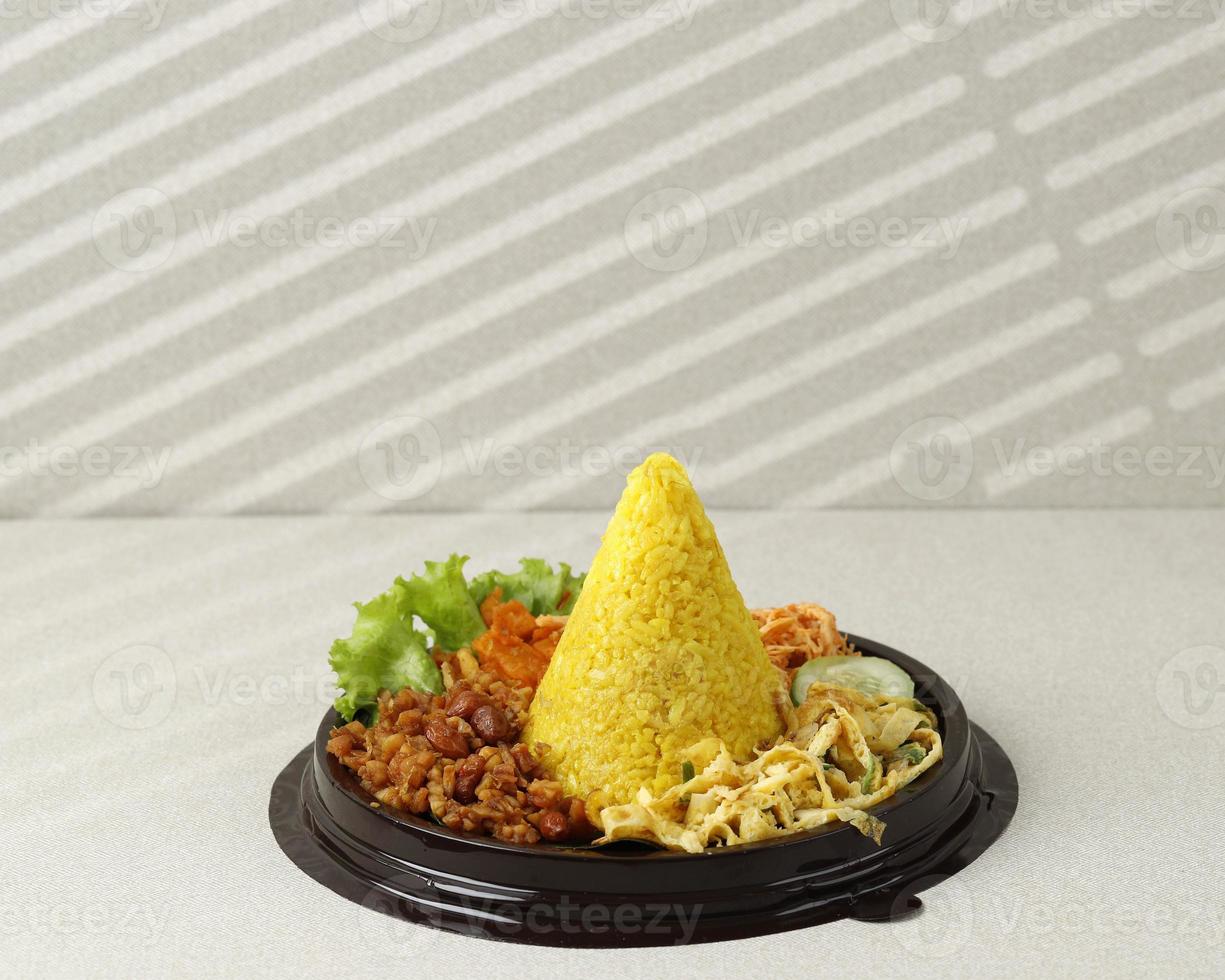 Small Cone Shaped Yellow Rice Or Tumpeng Mini Nasi Kuning. Indonesian Festive Food for Indoneia Independence Day photo