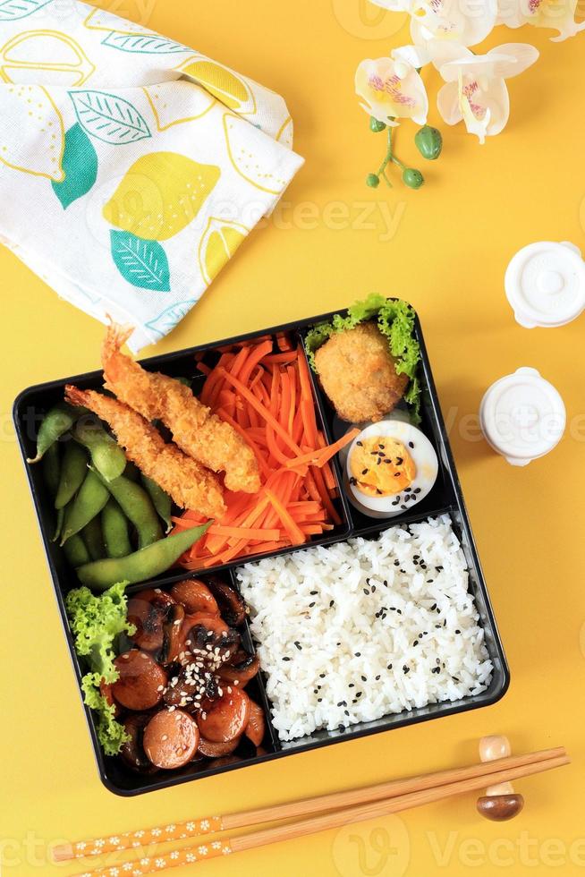 apanese Bento Lunchbox with Steamed Vegetable, Boiled Egg, Nugget, Sausage, Edamame, and Tempura photo