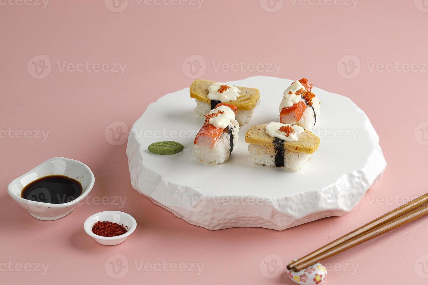 Tamago and Crabstick Roll Sushi on White Oriental Plate, Pink Background. photo