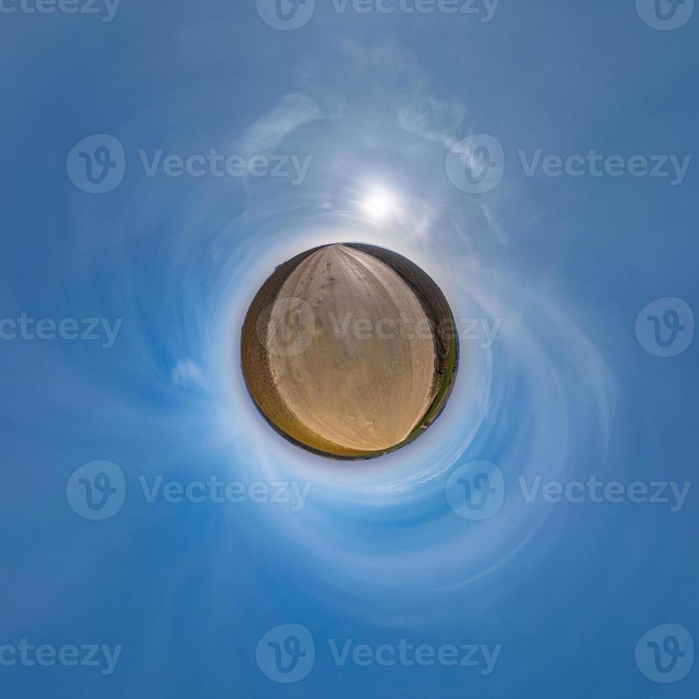 Little planet transformation of spherical panorama 360 degrees. Spherical abstract aerial view in field with awesome beautiful clouds. Curvature of space. photo