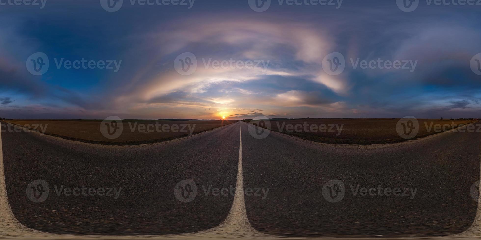 Full spherical seamless panorama 360 degrees angle view on no traffic asphalt road among fields in evening  before sunset with cloudy sky. 360 panorama in equirectangular projection, VR AR content photo