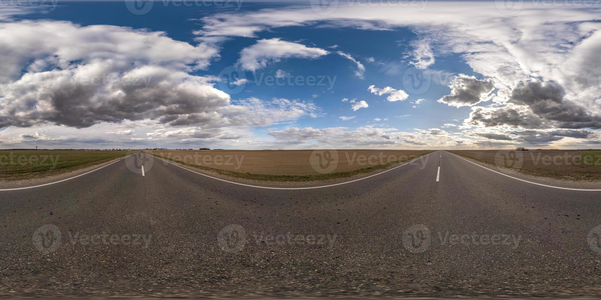 Full spherical seamless panorama 360 degrees angle view on no traffic asphalt road among fields in evening  before sunset with cloudy sky. 360 panorama in equirectangular projection, VR AR content photo