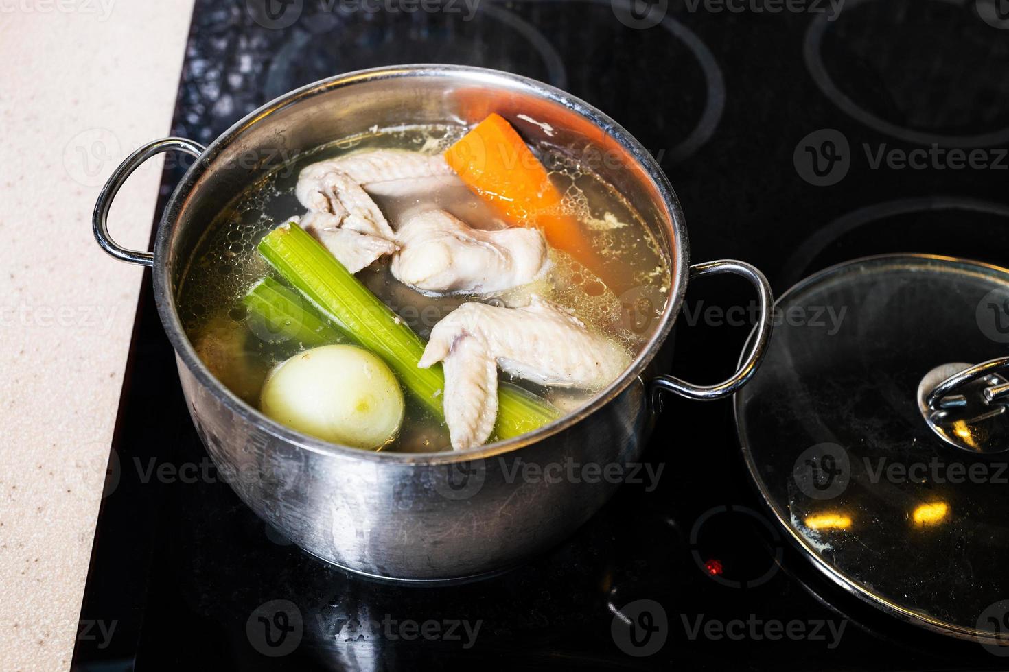 above view of chicken broth in stewpot on stove photo