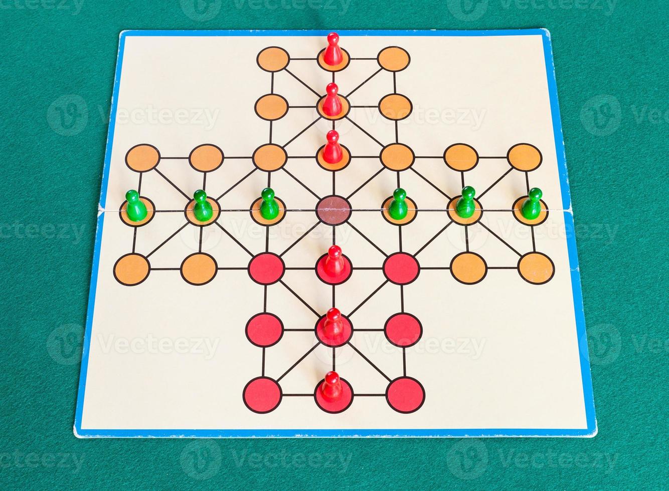 setup of cross solitaire board game on green table photo