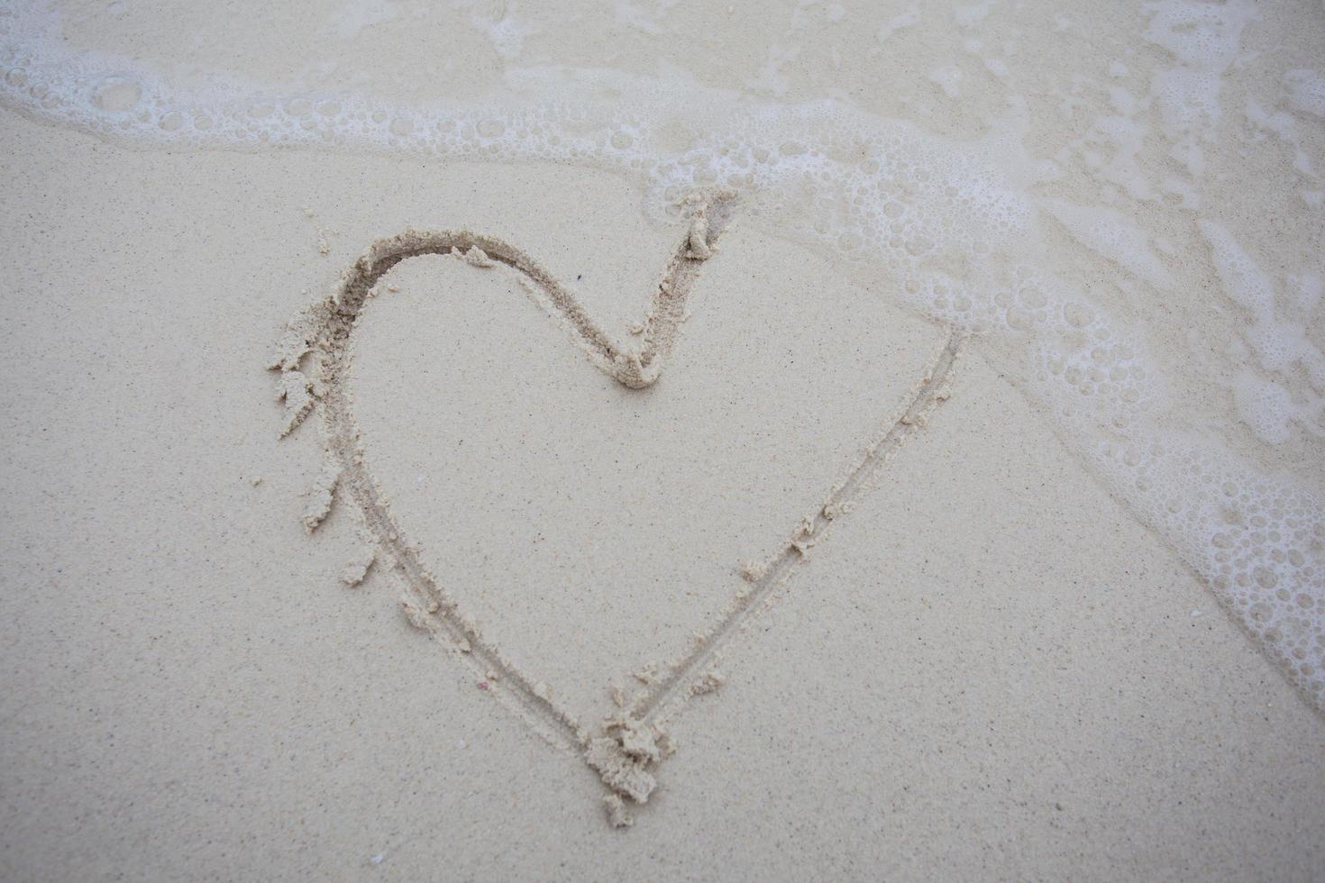 hearts drawn on the sand of a beach photo