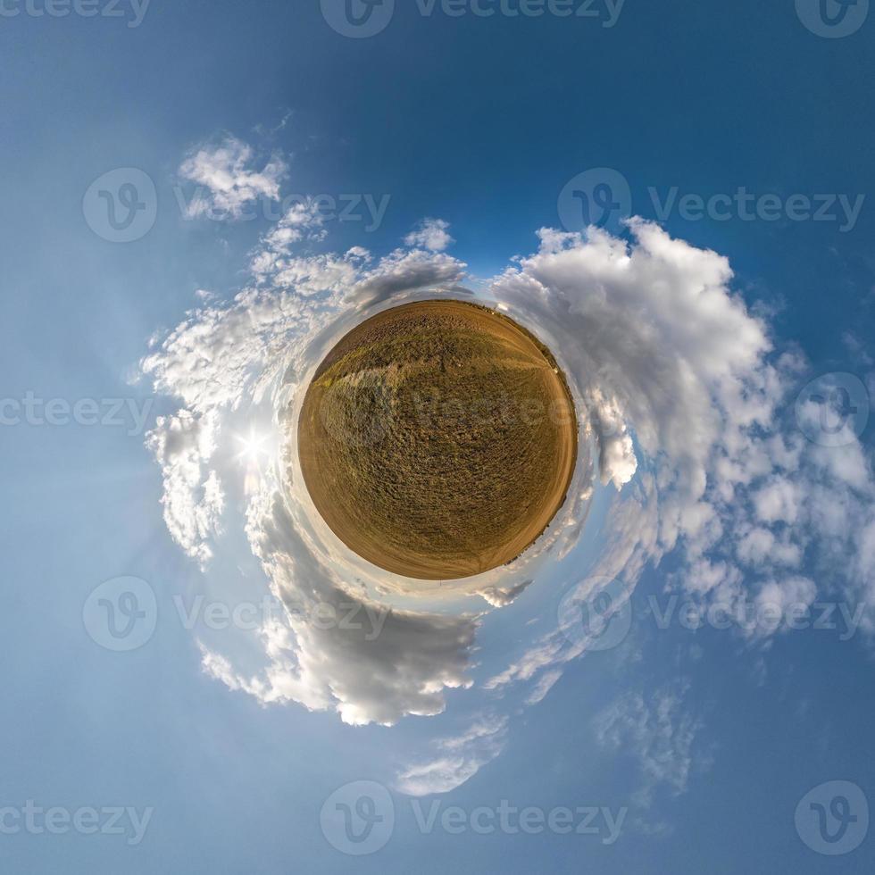 Little planet transformation of spherical panorama 360 degrees. Spherical abstract aerial view in field with awesome beautiful clouds. Curvature of space. photo