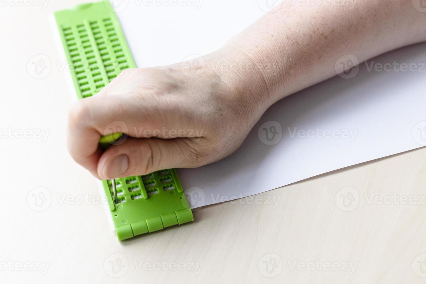 writing words in braille with slate and stylus photo