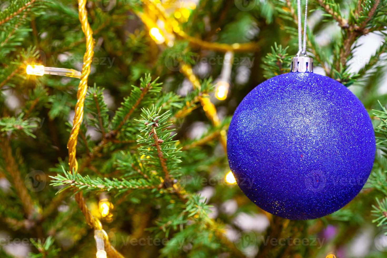 blue ball and light string on twigs of xmas tree photo