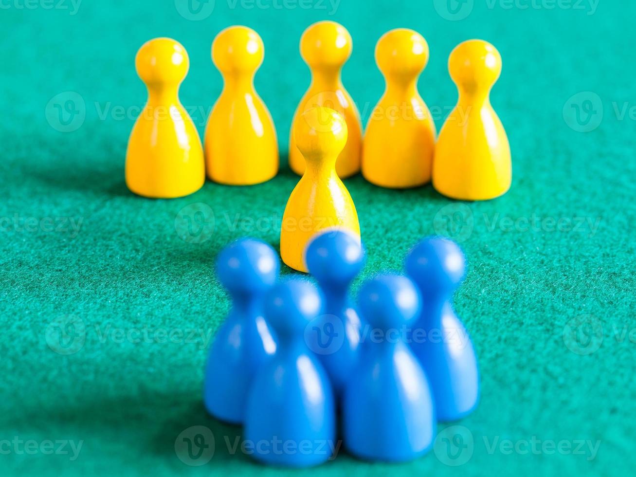 yellow pawns with leader in front of blue pawns photo