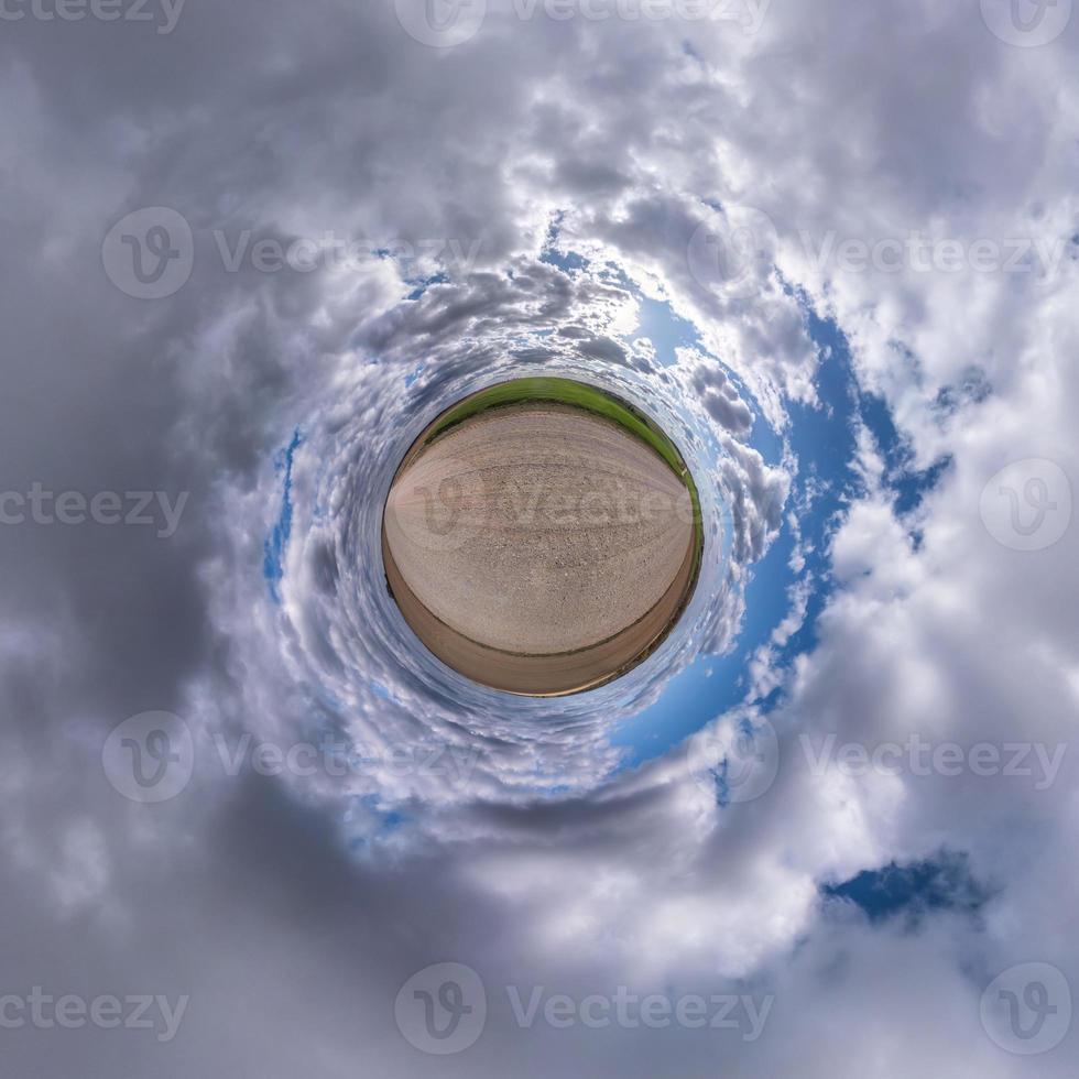 Little planet transformation of spherical panorama 360 degrees. Spherical abstract aerial view in field with awesome beautiful clouds. Curvature of space. photo