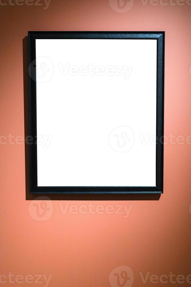 vertical narrow black picture frame on brown wall photo