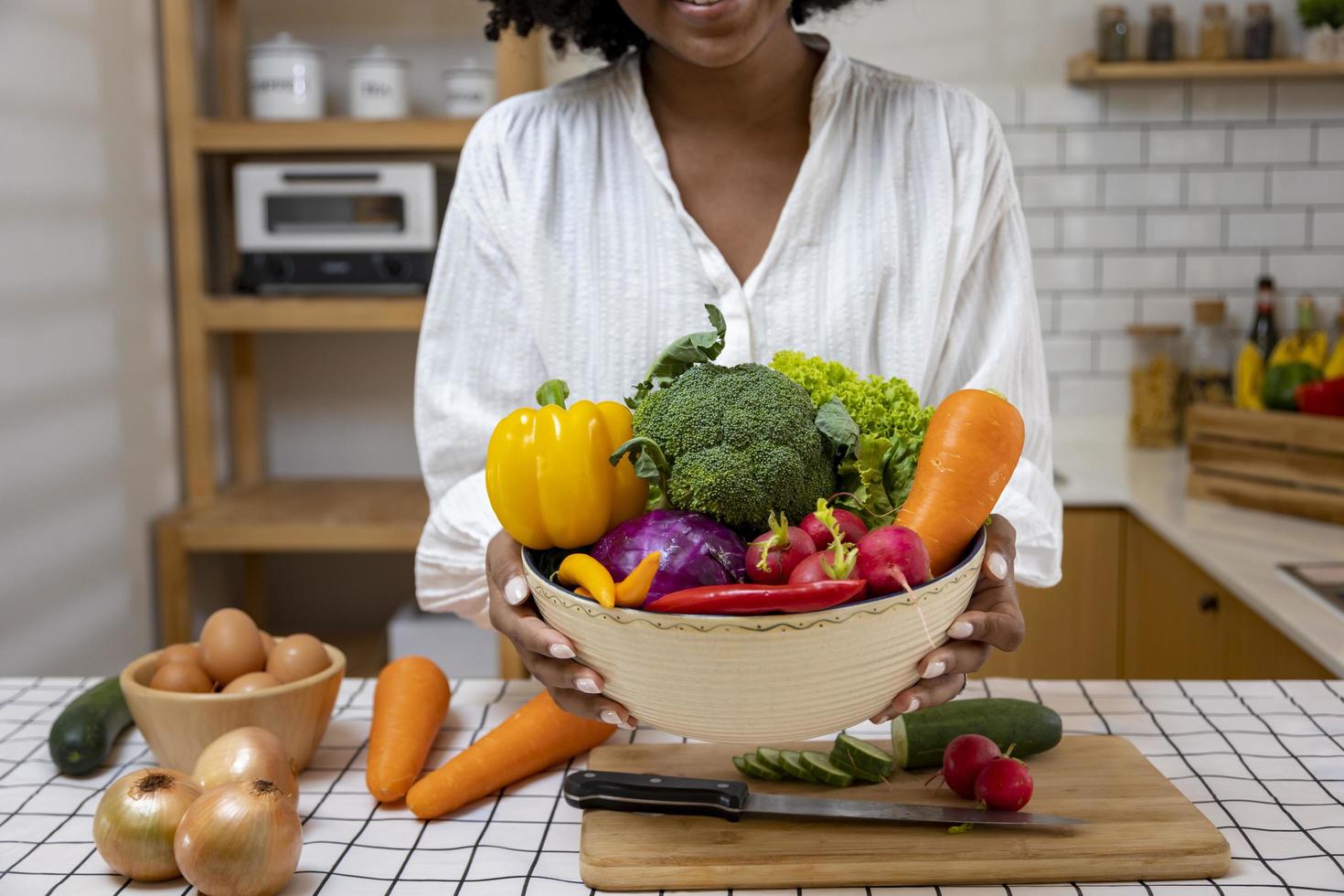 ama de casa afroamericana está mostrando una variedad de verduras orgánicas para preparar una ensalada simple y fácil de estilo sureño para comida vegana y vegetariana foto