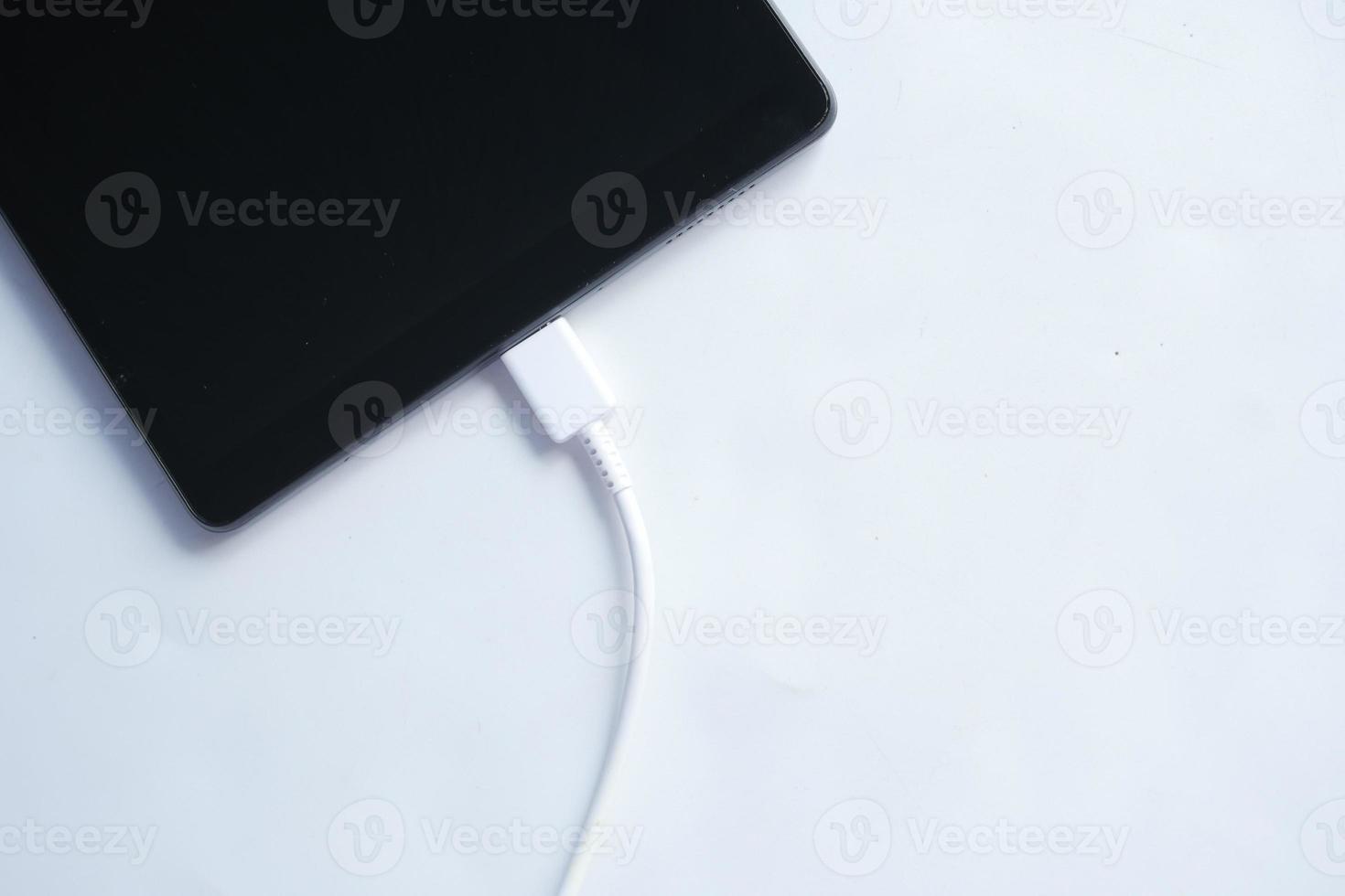 charging s digital tablet with a cable on white background photo