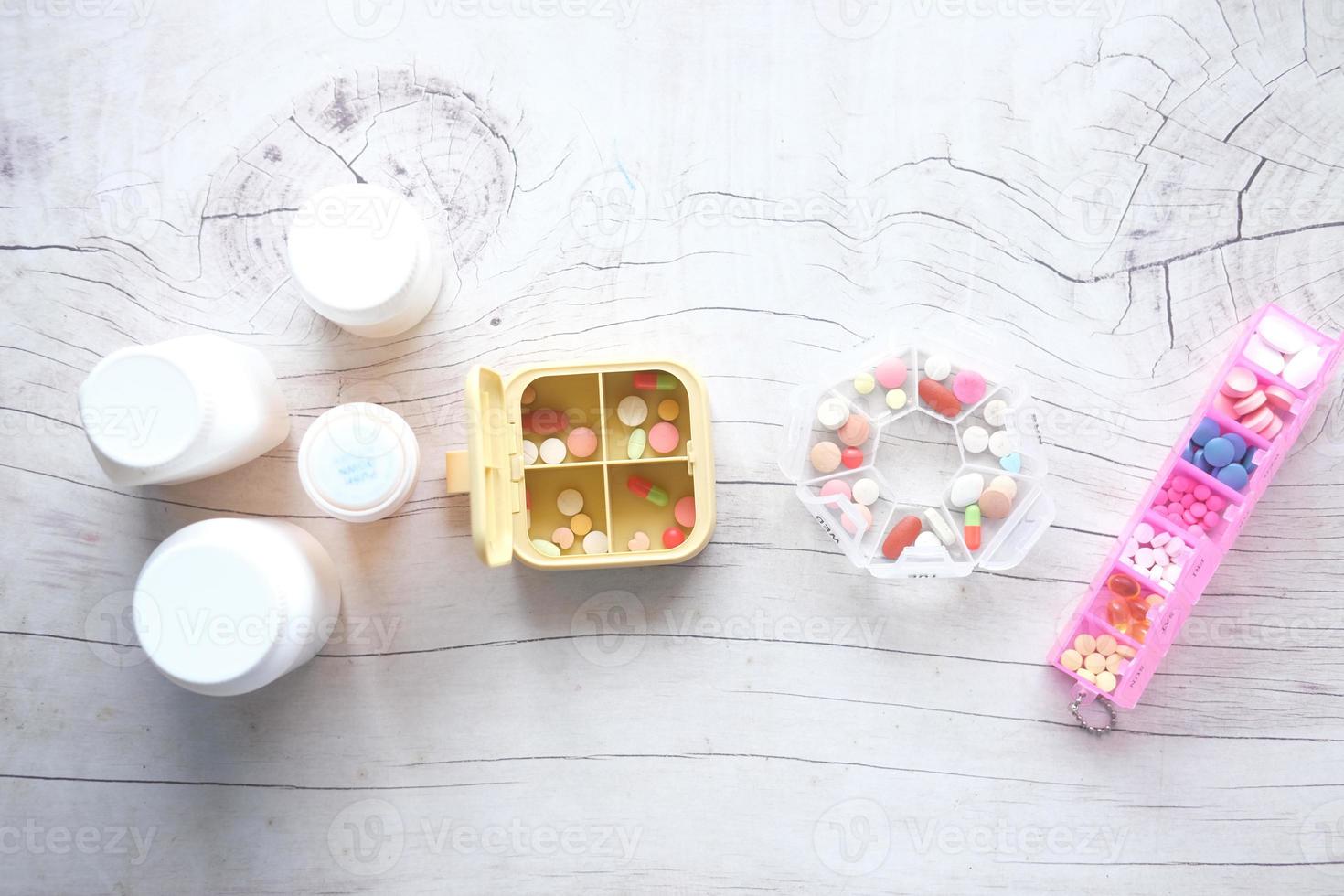 top view of medical pill box and container on table photo