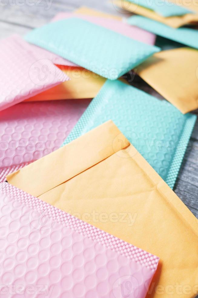 green and pink color paper bubble envelope on table photo