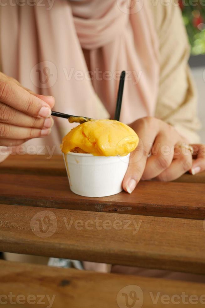 young women eating mango flavor ice cream photo