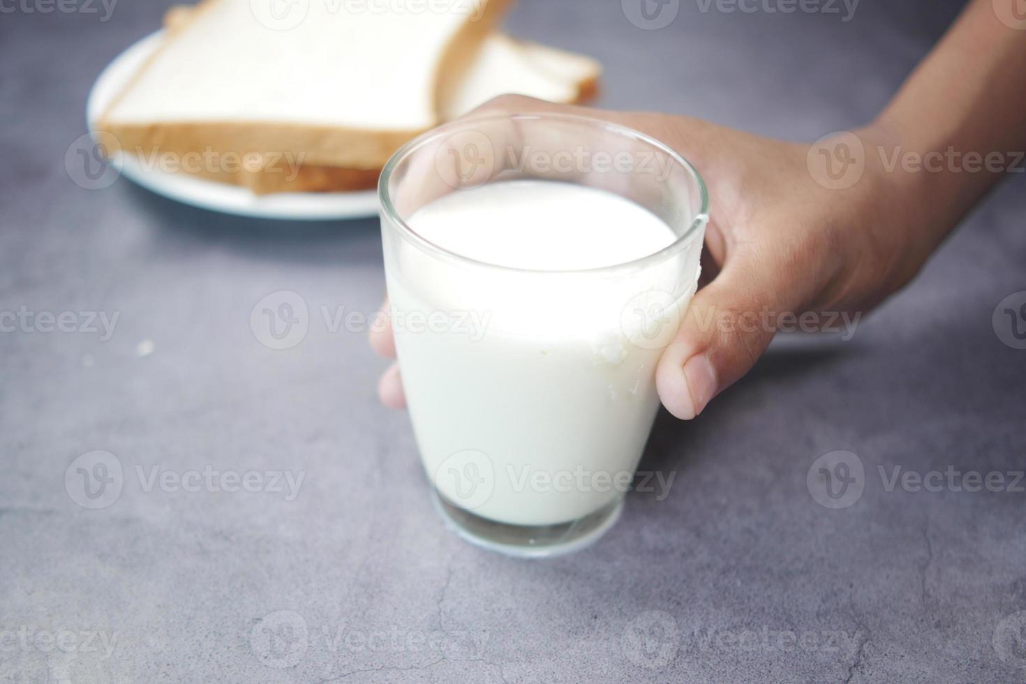 hand pick a glass of milk on black photo