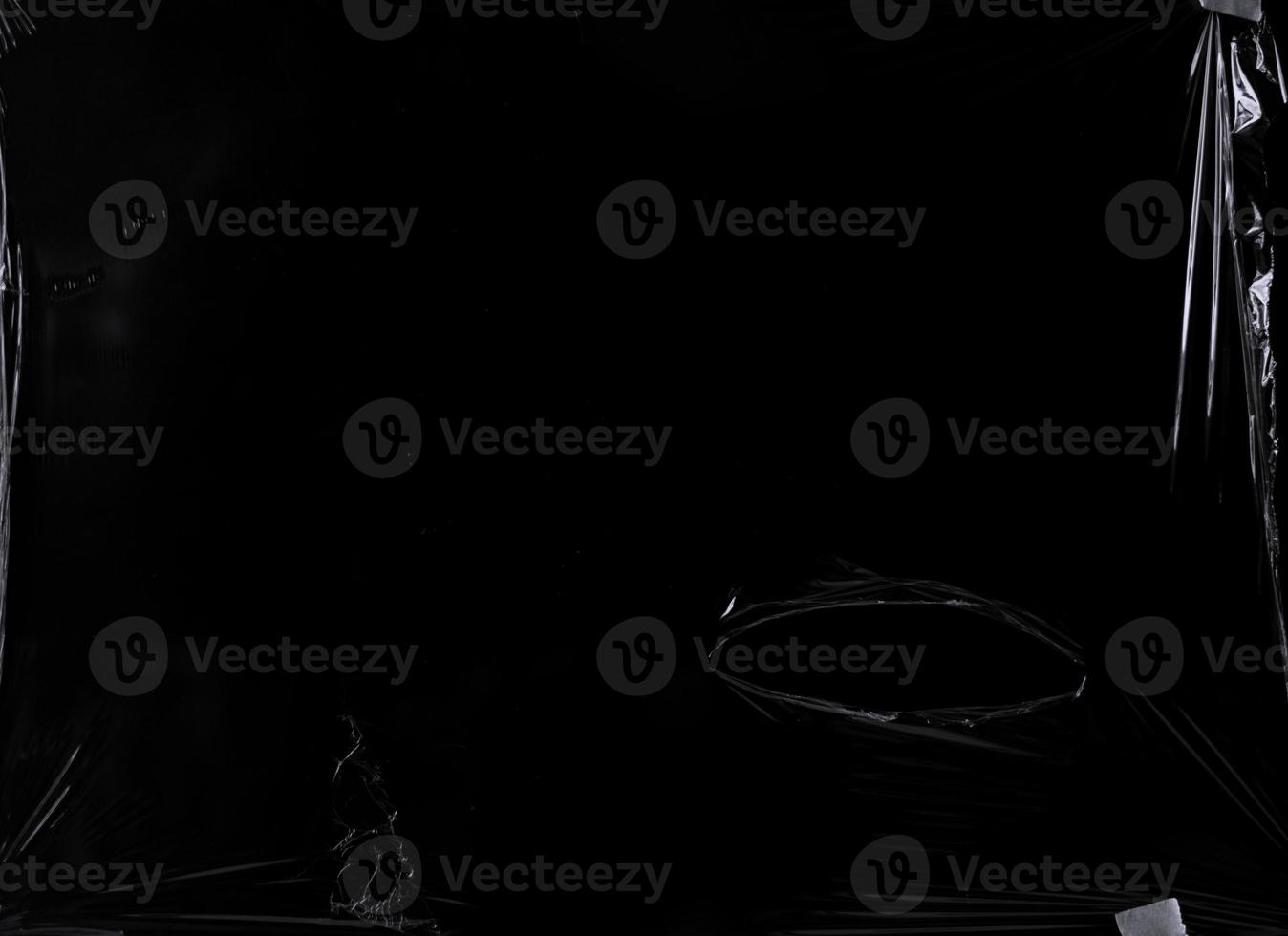 a black transparent plastic texture with hole for poster and cover art. realistic plastic wrap for overlay, copy space and photo effect. wrinkled plastic surface on black background