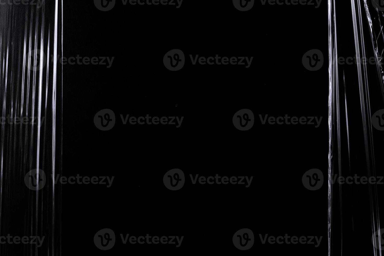 a black transparent plastic texture with hole for poster and cover art. realistic plastic wrap for overlay, copy space and photo effect. wrinkled plastic surface on black background