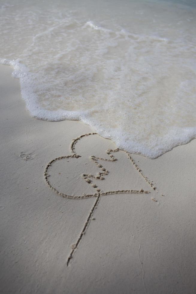 hearts drawn on the sand of a beach photo