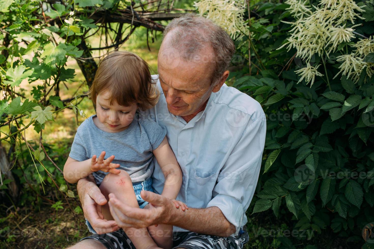 una niña abraza a su abuelo en un paseo al aire libre en verano. foto