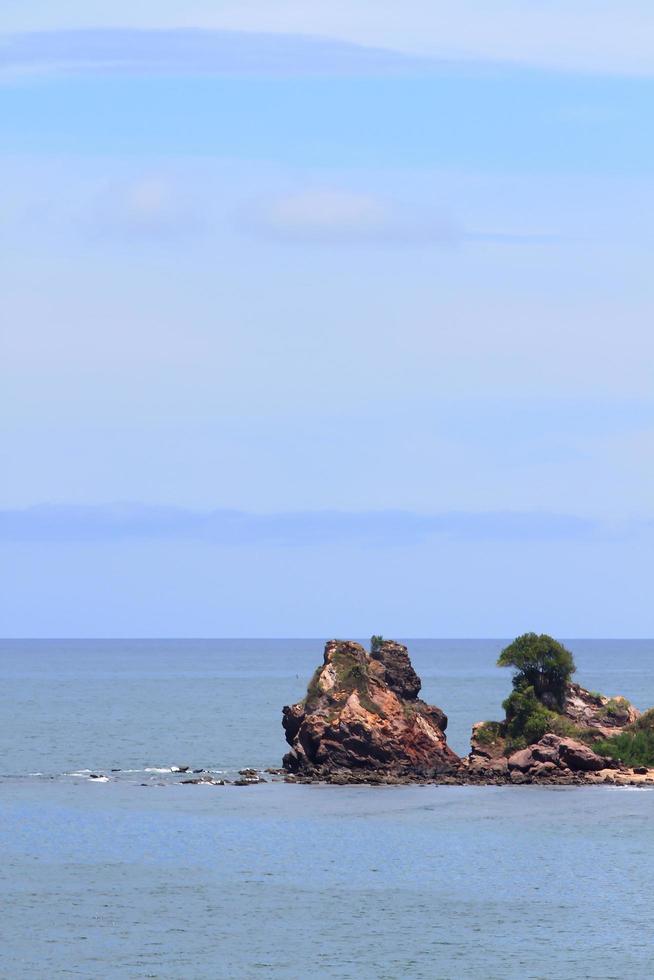 playa tropical con piedra y cielo foto