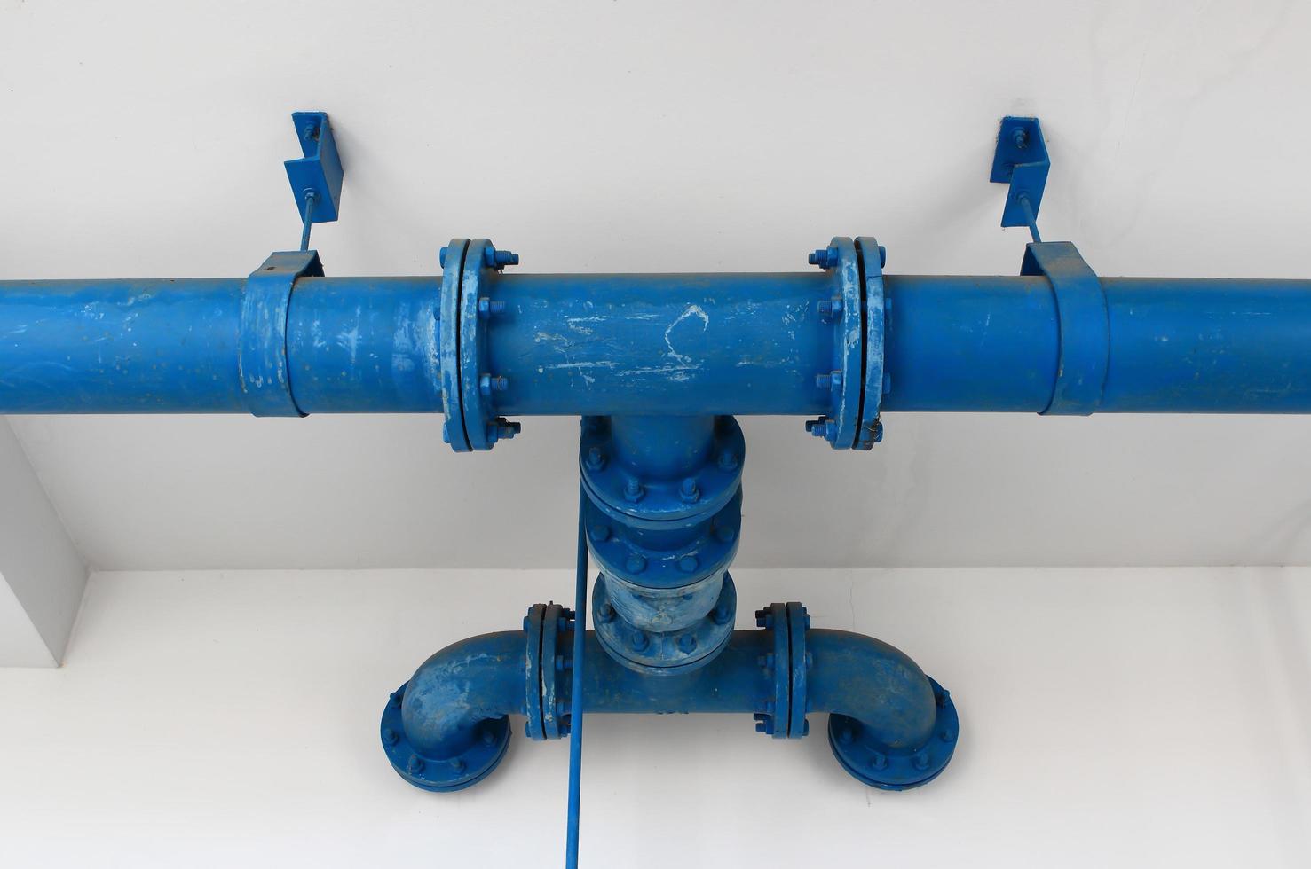 blue pipe line with blue valve on  wall photo