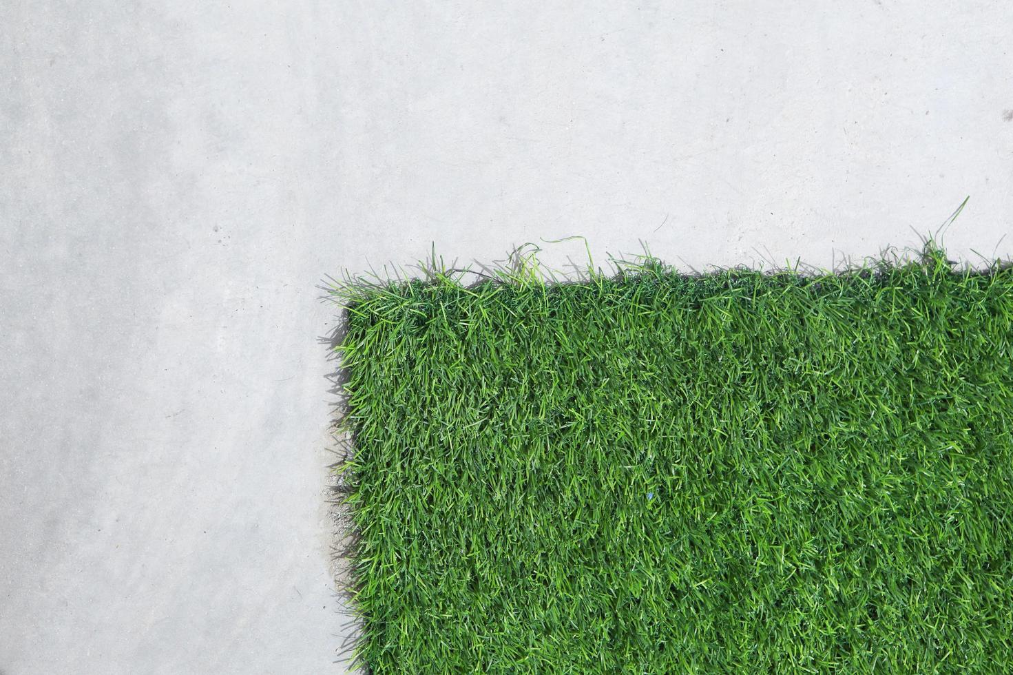 cement wall with artificial grass background photo