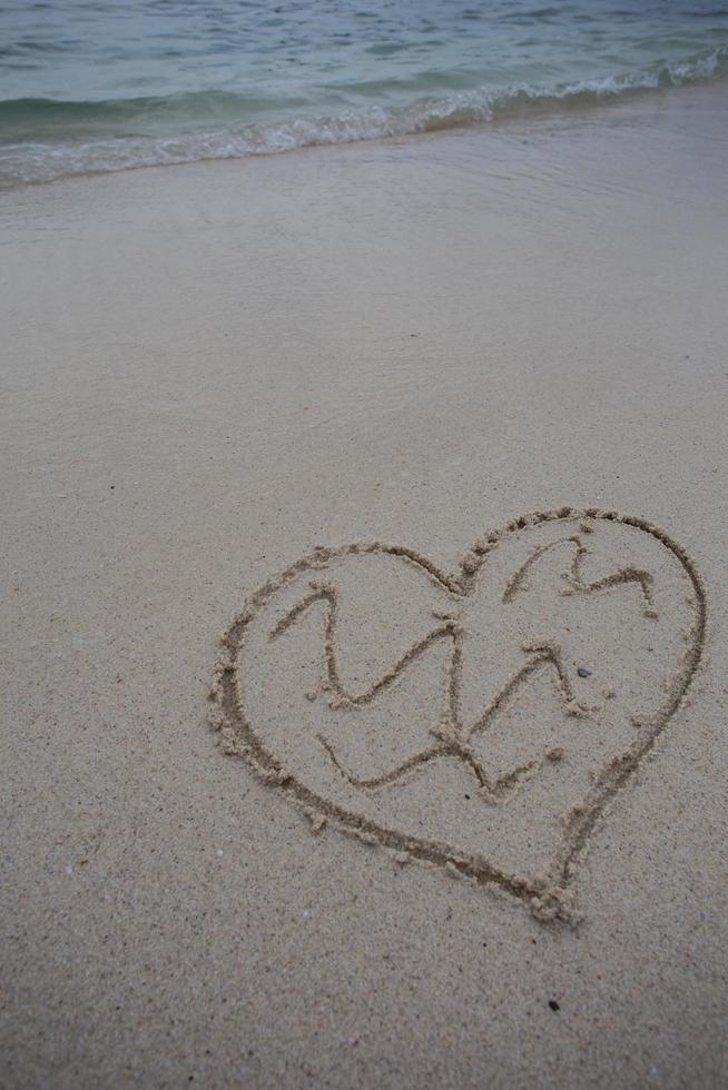 hearts drawn on the sand of a beach photo