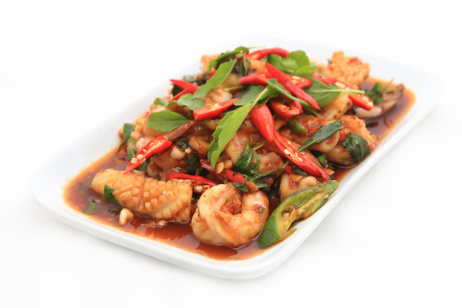 Spicy seafood fried served on white dish photo