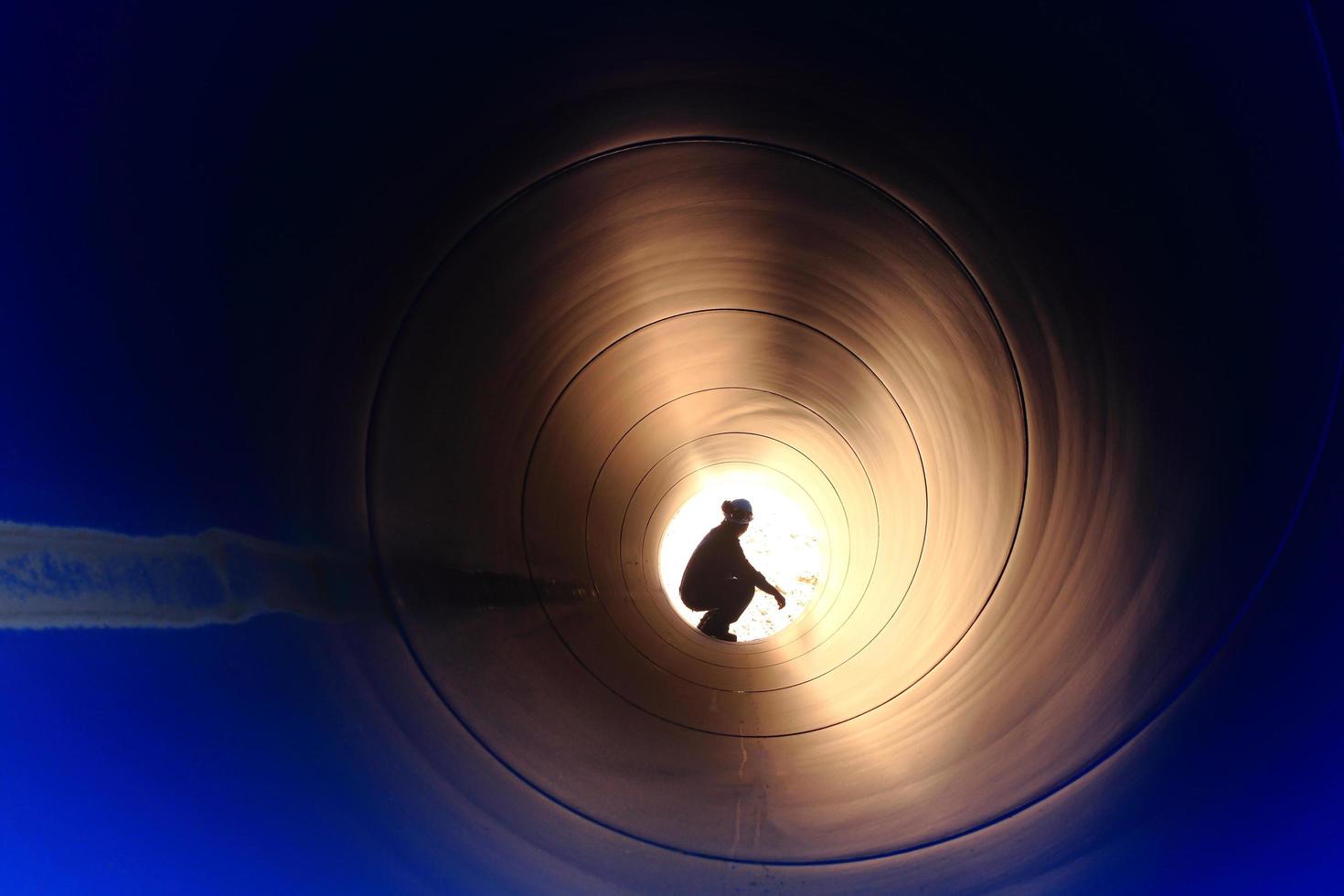 A silhouette of a worker in pipe photo