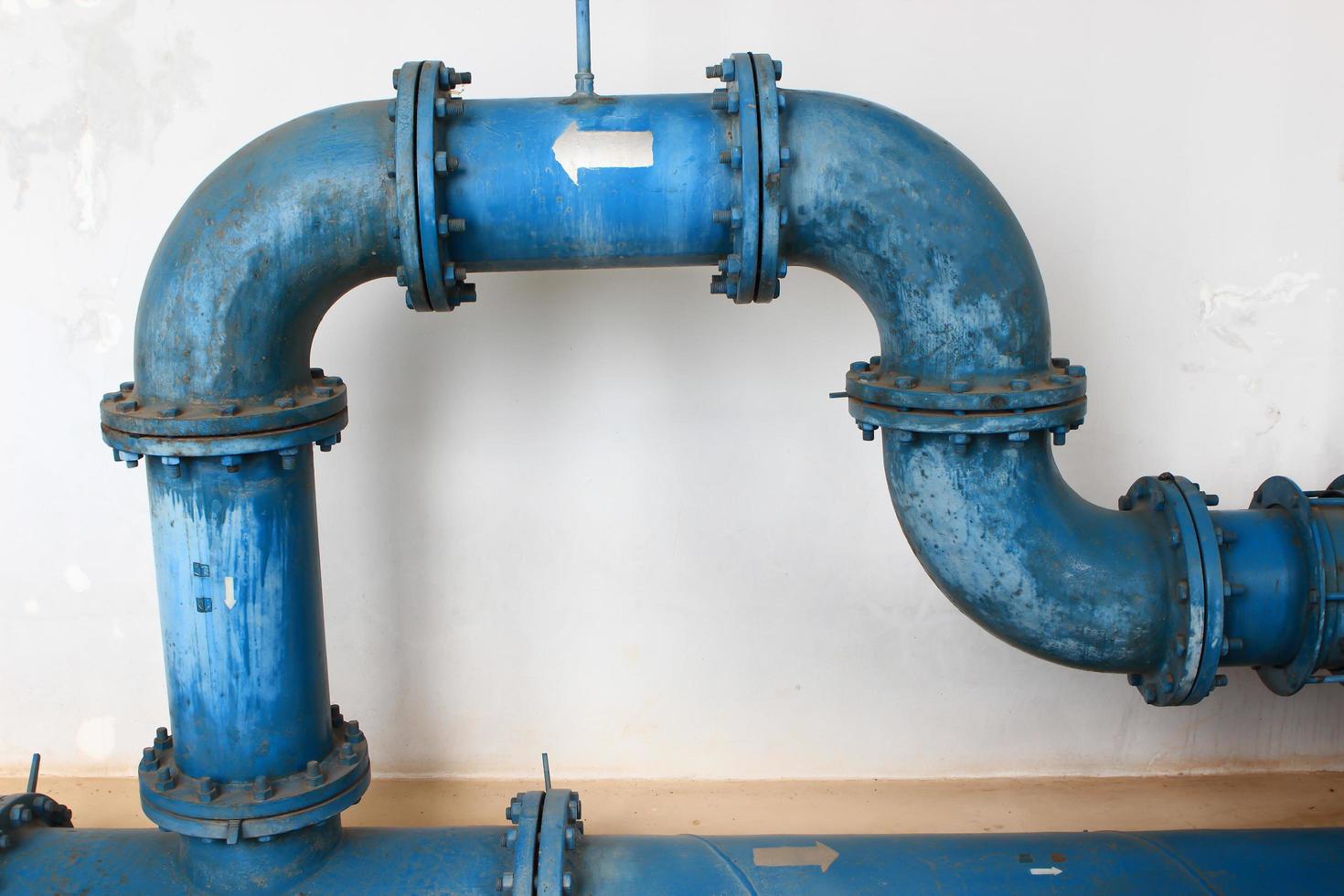 blue pipe line with blue valve on  wall photo