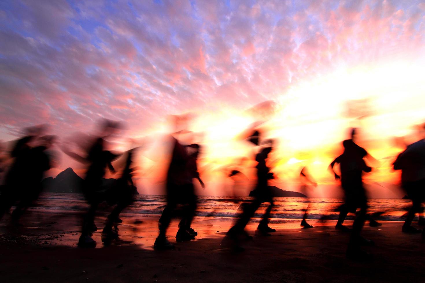 group of young people runs at the beach photo