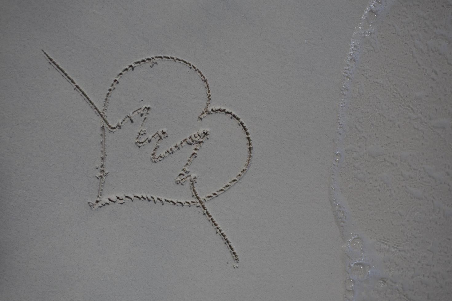 hearts drawn on the sand of a beach photo