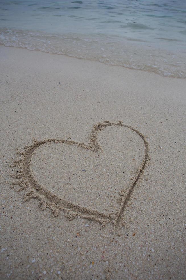 hearts drawn on the sand of a beach photo