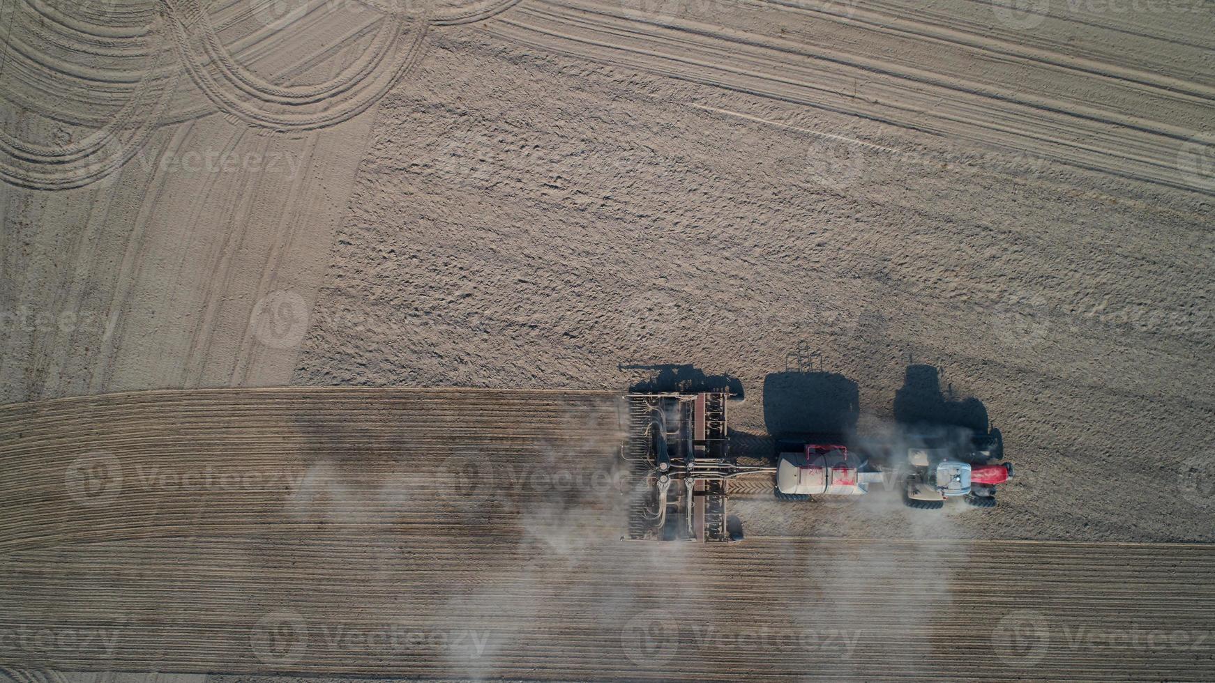 agricultor en tractor preparando tierra con cultivador de semillero, vista superior foto